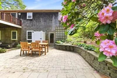 Private garden patio with outdoor dining and blooming landscaped views