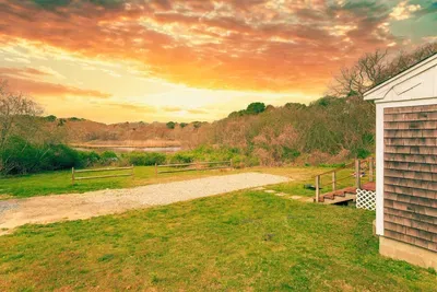 Sunset yard with pond view, gravel path, and serene nature escape