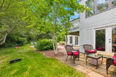Private backyard patio with wicker seating and lush green surroundings