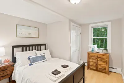 Bright, cozy bedroom with natural light and peaceful green views