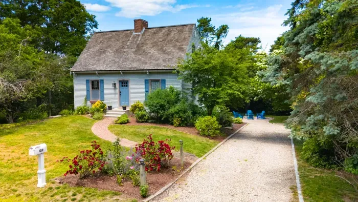 Charming cottage with lush gardens, private drive, and peaceful outdoor seating
