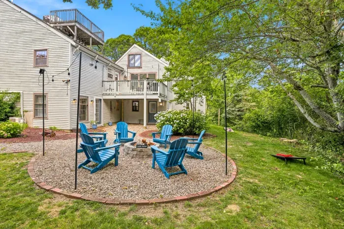 Private backyard fire pit with Adirondack seating and serene tree-lined views