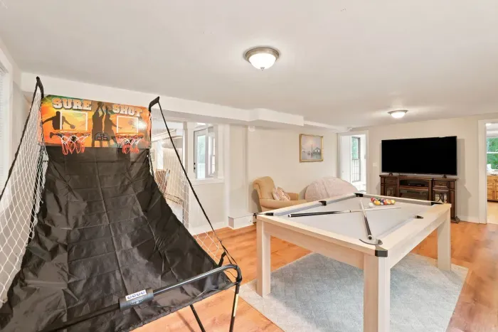 Game room with pool table, hoops, and big-screen TV for family fun
