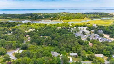 Aerial view of a lush coastal neighborhood near marsh and water