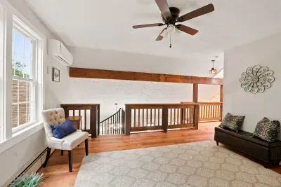 Bright loft sitting area with natural light, AC, and warm wood accents