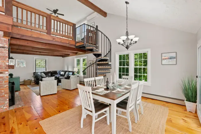 Bright lofted great room with spiral staircase and dining for six
