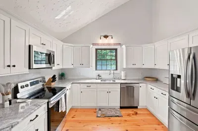 Bright vaulted kitchen with stainless appliances and abundant cabinetry