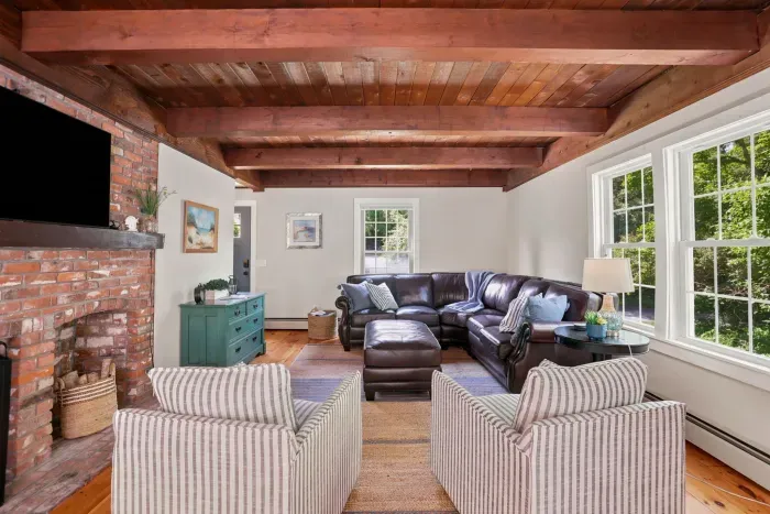 Cozy rustic living room with brick fireplace and sun-filled seating