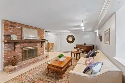 Cozy lounge with brick fireplace, piano, and inviting classic decor
