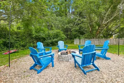 Private backyard fire pit with Adirondack chairs and cornhole fun