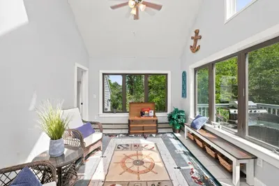 Sun-filled vaulted sunroom with wooded views and relaxing coastal charm
