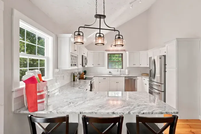 Bright modern kitchen with marble-style counters and spacious bar seating
