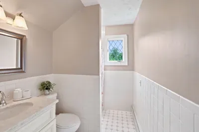 Bright, classic bathroom with marble vanity and charming natural light
