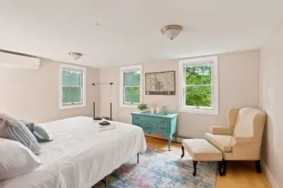 Bright bedroom with reading nook, natural light, and charming decor