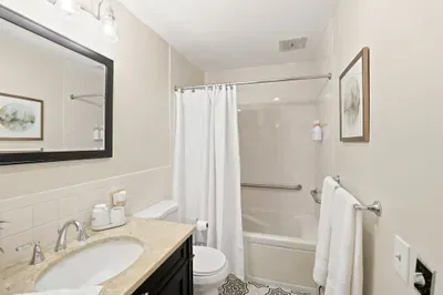 Bright, updated bathroom with granite vanity and tub-shower combo