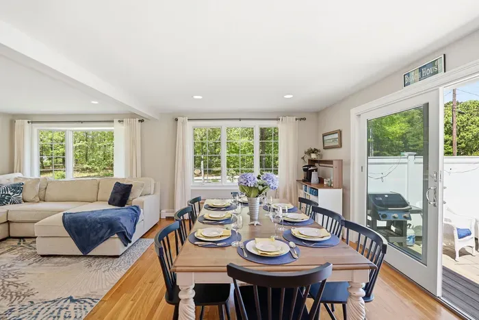 Bright open dining & living space with deck access and seating for eight with an additional table available upon request to seat a total of twelve.
