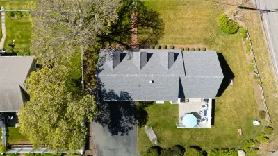 Your private green kingdom from above. Take in the sweeping scale of your tree-lined sanctuary, where a massive lawn meets a secluded deck built for long, sun-drenched afternoons in total isolation.