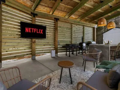 Step out back and relax under the custom pergola equipped with an 8-person hot tub, 65" smart TV, Blackstone grill, traditional propane grill, and swings facing the sunset!