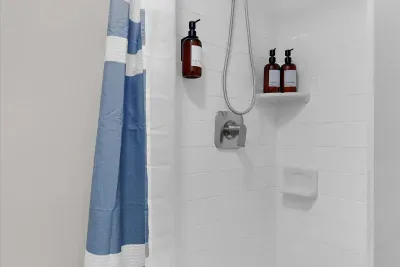 Bathroom #3 with walk in shower equipped with body wash, shampoo, and conditioner.