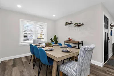 Spacious dining room area with seating for 8 and a convenient bar cart with wine glasses for our guests!