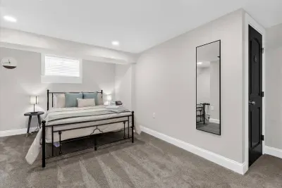 Bedroom #4 equipped with a queen size mattress and luggage rack.