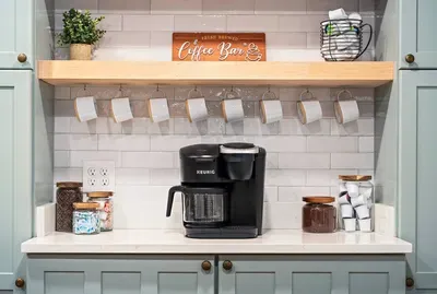 Coffee bar fully stocked with k cups, coffee beans, ground coffee, a Keurig with coffee pot, and cream and sugar to enjoy your mornings!