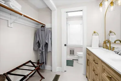 En suite full bathroom within the 3rd bedroom equipped with a custom walk-in shower, double vanity, robes for two, and all of the amenities needed to ensure you are well equipped!