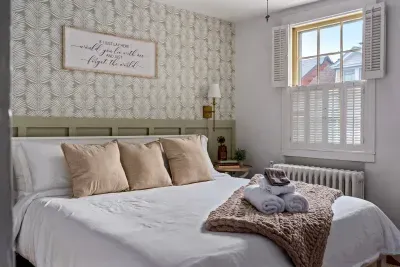 Cozy king bedroom with lots of natural light, ceiling fan, and a full length mirror for a truly luxurious stay!