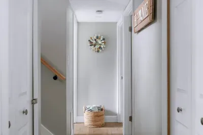 Downstairs hallway leading towards the 3rd and 4th bedrooms, 2nd full bathroom, and laundry room.