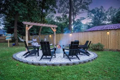 Cozy fire pit with 2 hanging egg chairs ready for s’mores making!