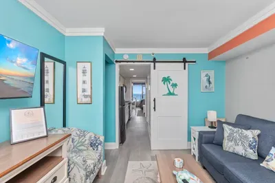 Bright coastal living room with beachy décor and charming barn door