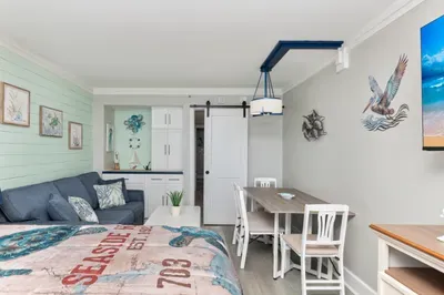 Coastal-chic studio with dining space, sofa, and stylish beach decor