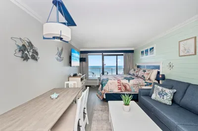 Coastal-inspired room with sofa, balcony, and beautiful ocean views