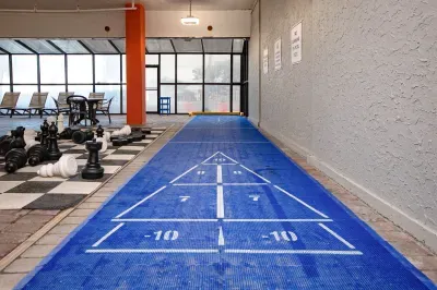 Covered game area with shuffleboard, giant chess, and lounge seating