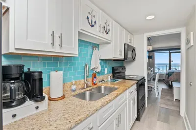 Bright coastal kitchen with granite counters and ocean-view layout