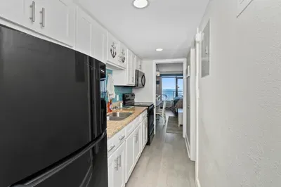 Bright coastal kitchen with stylish finishes and ocean-view balcony access