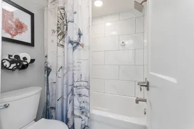 Bright coastal bathroom with tiled tub-shower and modern finishes