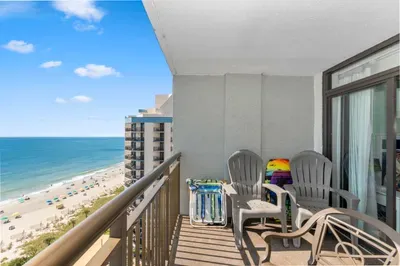 Private ocean-view balcony with comfy seating above the beach