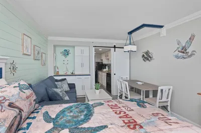 Cozy coastal studio with dining nook, loveseat, and beachy charm