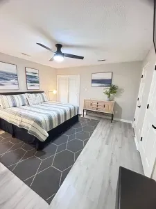 Spacious coastal-inspired bedroom with a large bed, stylish decor, and bright open feel