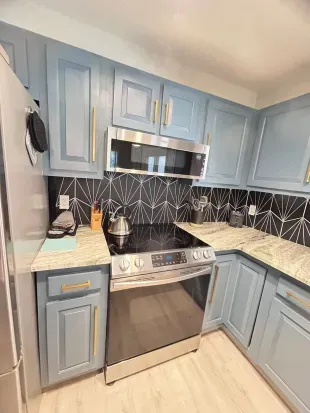 Modern kitchen with stainless appliances and chic geometric backsplash