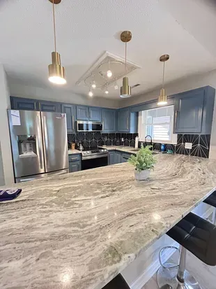 Modern chef’s kitchen with oversized island, bar seating, and sleek finishes