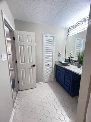 Bright modern bathroom with bold blue vanity and stylish hex tile floor