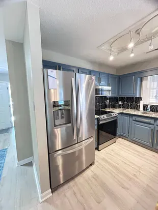 Modern kitchen with stainless appliances and stylish geometric backsplash