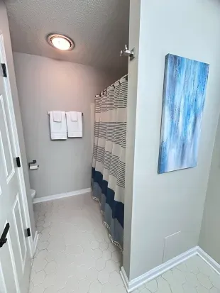 Bright modern bathroom with hex tile floors and stylish blue accents