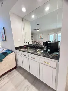Chic coffee bar with mirrored backsplash and elegant marble-style counter
