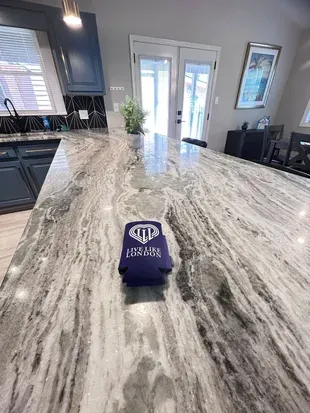 Spacious designer kitchen island with stunning stone countertops and natural light