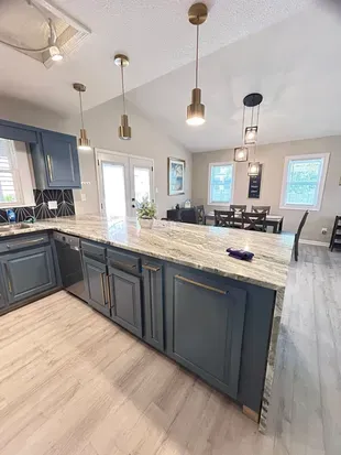 Bright modern kitchen with large island, vaulted ceilings, and dining space