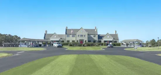Elegant golf clubhouse with carts, dining, and easy tee-time access by manicured greens.