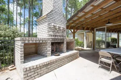 Covered patio with brick fireplace—ideal for cozy outdoor dining.